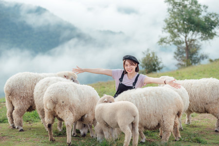 A happy moment of a female farmer and her sheep.の写真素材