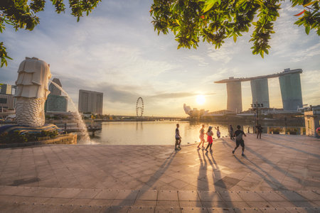 Experience the enchanting sunset over Marina Bay in Singapore, featuring the iconic Merlion and skyline, perfect for travel enthusiasts and photographers.の写真素材