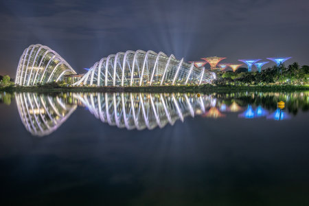 A captivating night view showcasing modern architecture reflected in calm waters. The vibrant lights and serene environment create a stunning visual experience.の写真素材