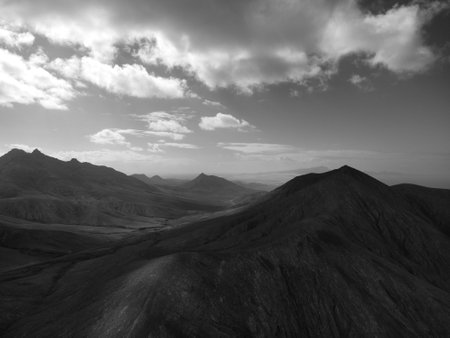 Black and white image of a mountain landscape with a dramatic sky.の写真素材