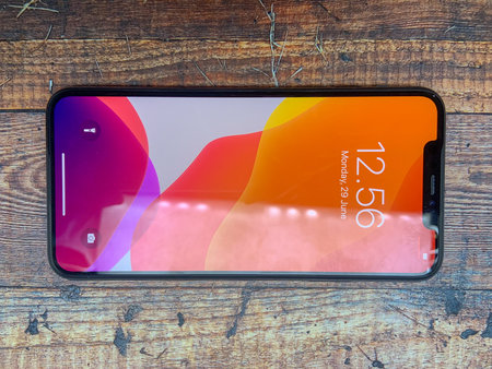 BALI, INDONESIA JUNE 29, 2020: Iphone X It has been used on a table with a wooden texture, top view....