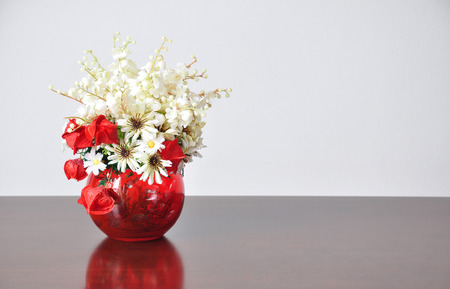 Vases artificial flowers on the wood desk, The back wall is concrete.の写真素材