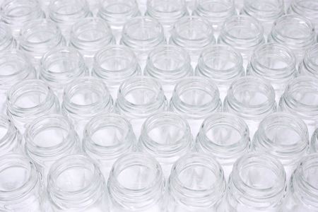 Short glass bottle no cap many glasses row, on white background.の写真素材