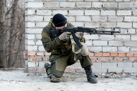soldier in camouflage uniform with an automatic rifle