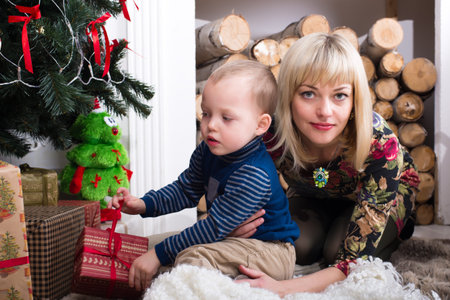 Mom and son playing near the Christmas treeの写真素材