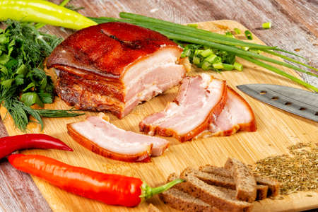 smoked meat lies on the table with herbs and sauceの写真素材