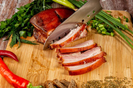 smoked meat lies on the table with herbs and sauceの写真素材