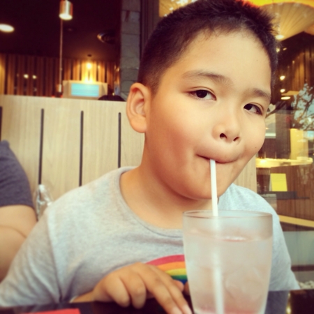 Boy drinking water in Japanese restaurant Bangkok Thailandの素材