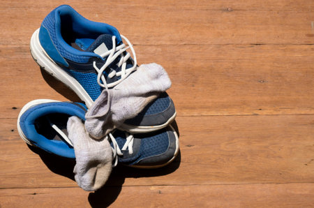 Sport shoes and socks put on a wooden floor at home  after coming back from morning jogging. Exercise for a good health.の写真素材