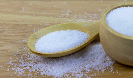 Monosodium glutamate in  spoon on wooden table. MSG a flavour enhancer of many Thai food and asian...