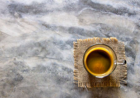 Top view cup of black americano on sackcloth and rustic concrete table. The good flavor drinks from an organic arabica coffee. Morning refresh concept. Copy space.の写真素材