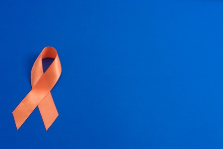 Orange ribbon on blue background. healthcare and medicine concept. Multiple Sclerosis awareness. Leukemia awareness. Kidney cancer awareness.の写真素材