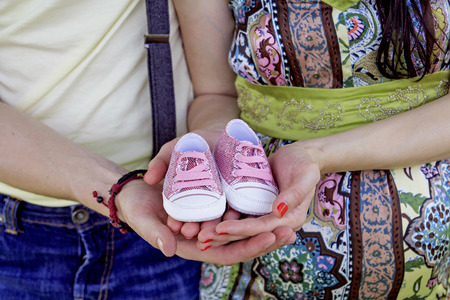 Pregnant couple holding their future baby boots. Concept of pregnancy,の写真素材