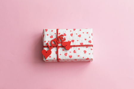 Valentines day concept with hearts and gift box. gift box with a red heart on pink background. Present box with red ribbon.の写真素材