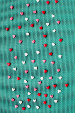 Valentine day on greene background with red and white hearts, top viewの写真素材