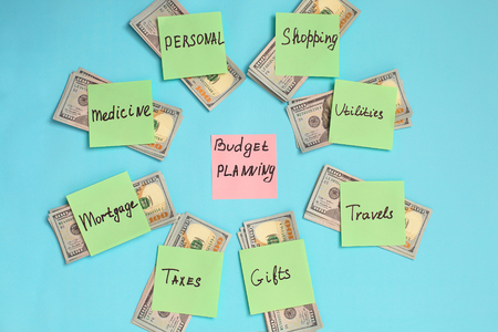 Budget planning concept. Top view of notepad with word Budget, and money on blue background.の写真素材