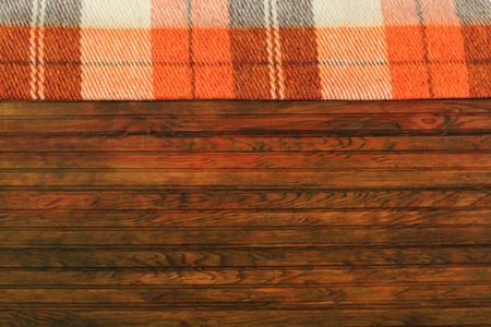 Orange plaid in a cage on a wooden autumn background. Autumn conceptの写真素材