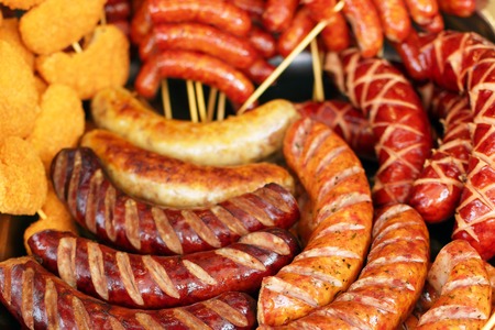 Mix grilled sausages on pan with spices, outside. Fried sausages with herbs.の写真素材