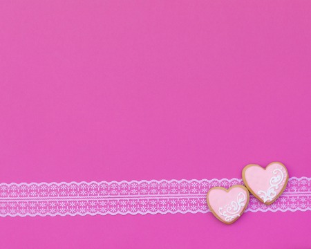 Heart shaped cookies decorated for Valentine's Day on pink background. Free space for text. Like postcard wedding invitationの写真素材