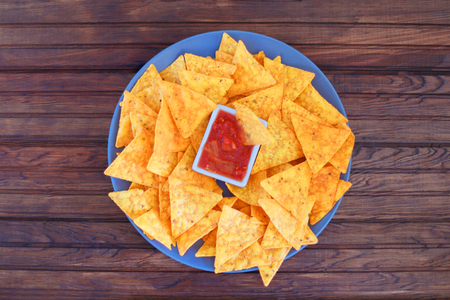 Nachos corn chips with spicy sauce on the table. Horizontal view from aboveの写真素材