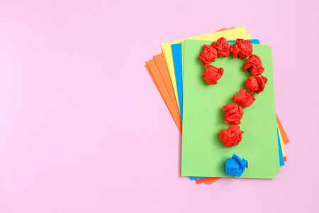 Red question mark lined with crumpled paper balls on colorful background top view copy space. Asking, Decisions. FAQ concept. Concept ideas. Flat lay.の写真素材