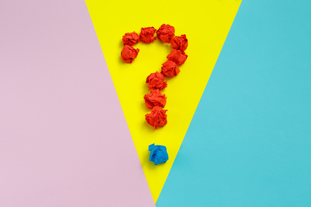 Red question mark lined with crumpled paper balls oncolorful background top view copy space. Asking, Decisions. FAQ concept. Concept ideas. Flat lay.の写真素材