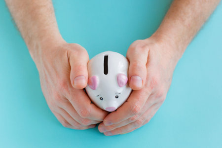 Man holding big pink piggy bank on blue background. Investment concept