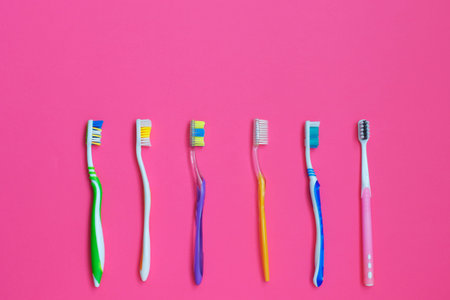Set of different toothbrushes on pink background. Personal care concept. Flat lay