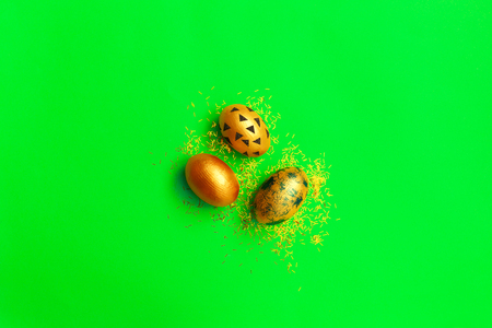 Top view of easter eggs colored with golden paint in different patterns on green background. Copy space. Happy Easter concept. flatlay.の写真素材