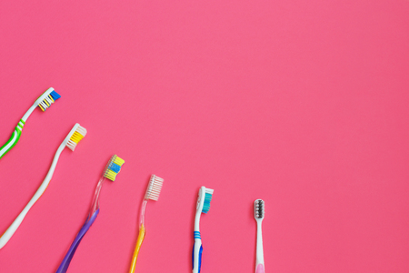 Set of different toothbrushes on pink background. Personal care concept. Flat lay. space for textの写真素材