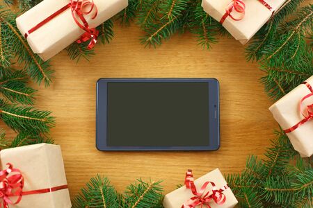 Christmas background. New Year's holidays. Christmas holidays. Beautiful Christmas decorations on the wooden background. Digital technology. Tablet copy space textの写真素材