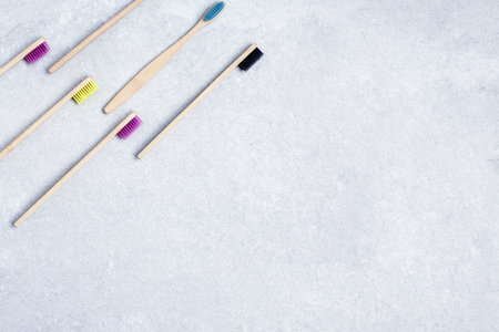 set with bamboo toothbrushes on stone background.