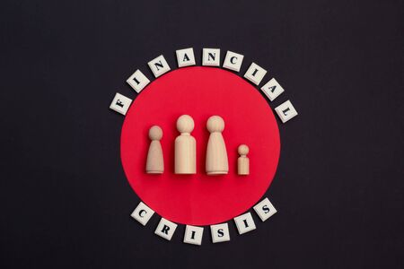 Phrase Financial Crisis and wooden family figures. the lack of money concept. Financial crisis in the family. Bankruptcy of a private person. Failure to fulfill obligations to the bank concept.の写真素材