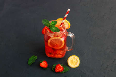 Cold strawberry lemonade juice with ice cubes, lemon and mint.の写真素材