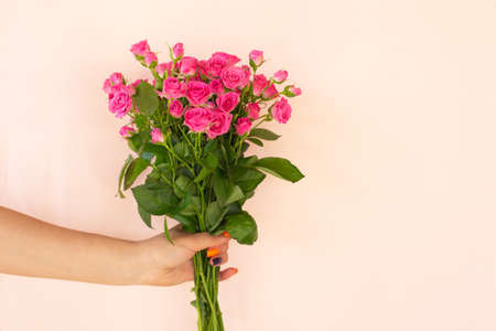 Girl's hands holding Beautiful bouquet of pink roses on light background Copy space. Birthday, Mother's, Valentines, Women's, Wedding Day concept.の写真素材
