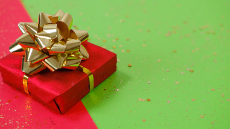 Gift or present box and confetti on red and green backgraund. Flat lay composition for christmas