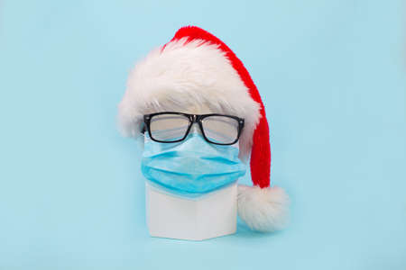 Santa Claus hat and glasses with face mask on geometric shape.の写真素材