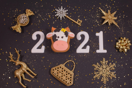Happy New year 2021 with golden decoration, glitter and Gingerbread bull on black background....