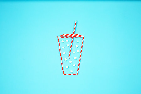 Cup of Christmas hot drinks theme on blue background. Tea, hot chocolate with marshmallow. Creative winter minimal concept. Unique flat lay.の写真素材