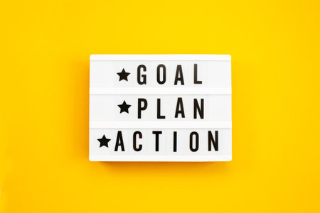 Goal, Plan, Action text on light box on yellow background.の写真素材
