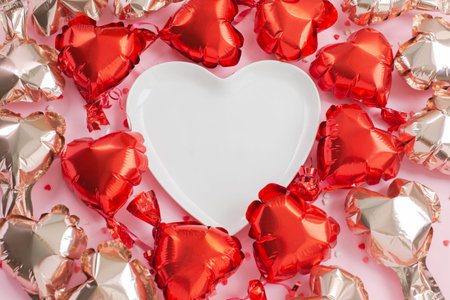 Air Balloons of heart shaped foil around a white heart-shaped plate.