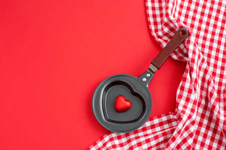 Heart shaped black metal egg frying pan with candyの写真素材