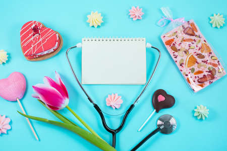 Pink tulips and stethoscope with spiral notepad with Happy Doctors Day text on it.の写真素材