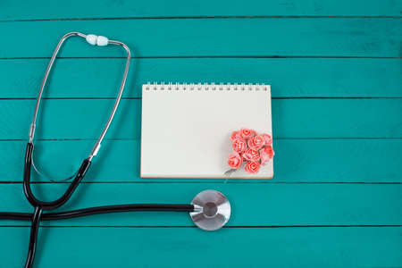 Stethoscope with small flowers and open notebookの写真素材
