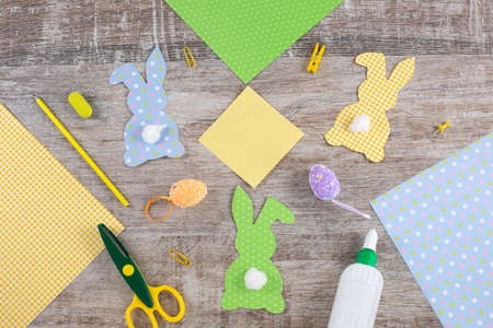 Colorful Easter paper bunnys, rabbits with a tail on wooden table.の写真素材