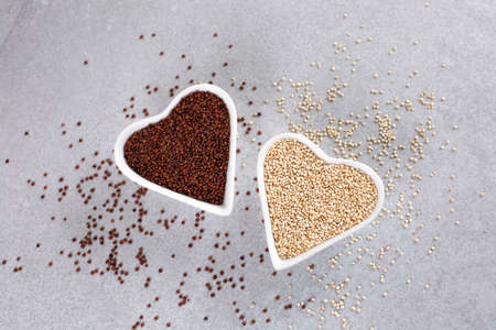 Red and white Quinoa in heart-shaped bowl on stone background.の写真素材