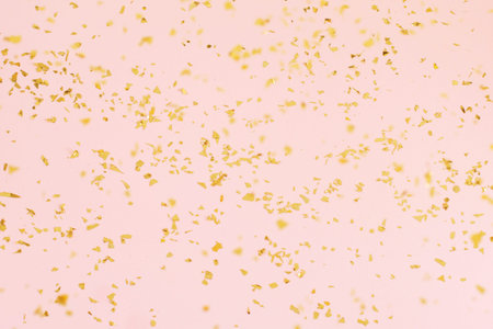 Falling Golden confetti on light trendy background.の写真素材