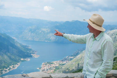 Man stands the beautiful nature landscape and points a finger to beautiful places, Montenegro.の写真素材