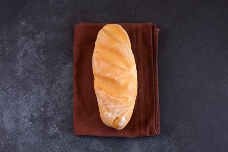 Whole White loaf of bread on black background.
