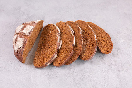 Sliced rye bread on a grey table.